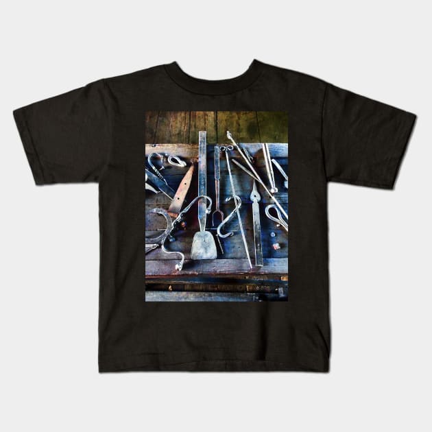 Blacksmith Tools on Table Kids T-Shirt by SusanSavad